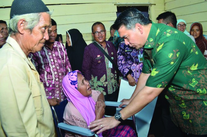 Walikota menyerahkan bantuan kursi roda.